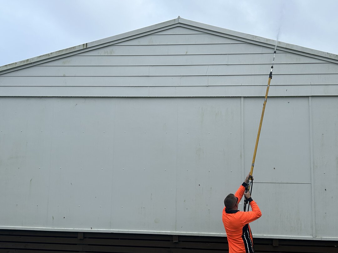 Cleaning a Flashing Soft washing a a cream coloured roof flashing through a hose extension.