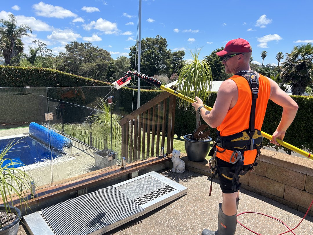 Man holding a brush as he is cleaning a metal panel.