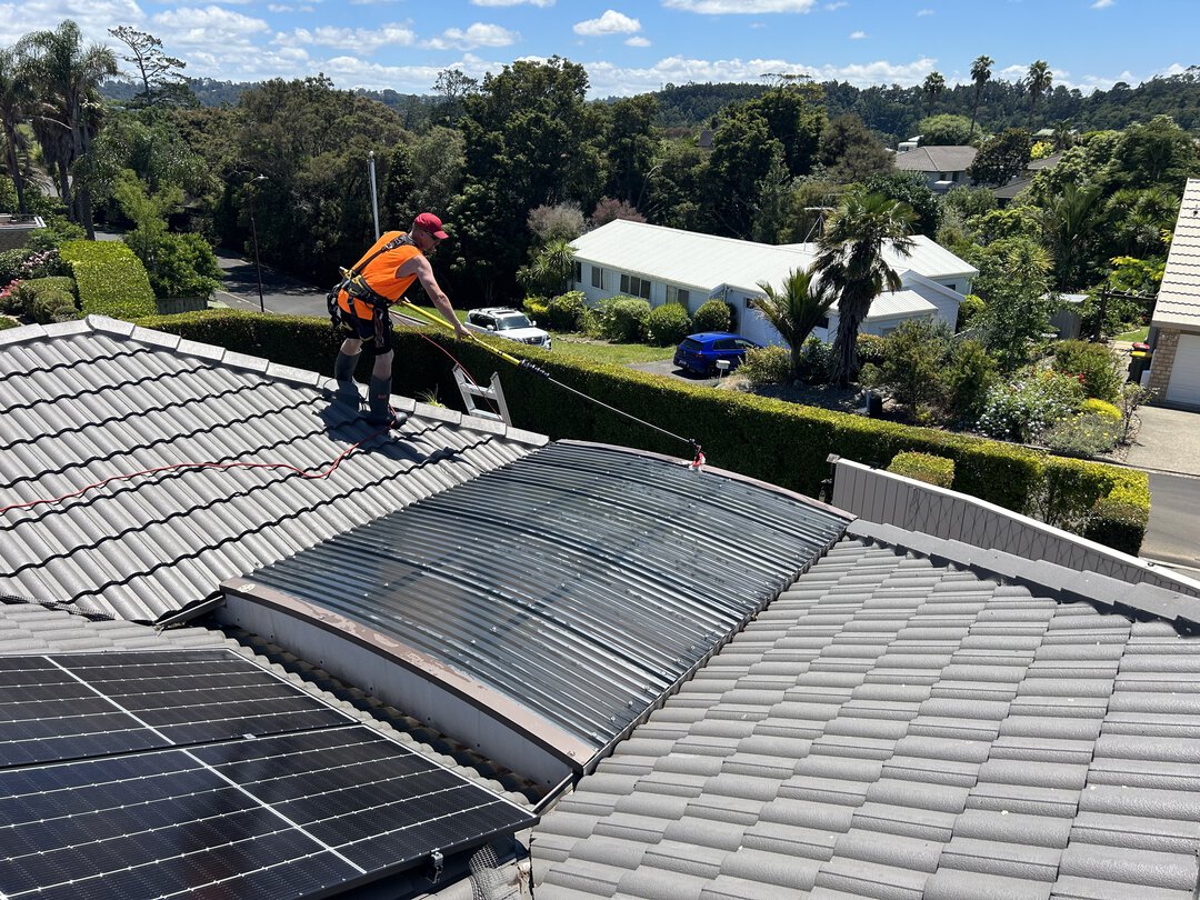 Man cleaning a roof flashing with a brush.